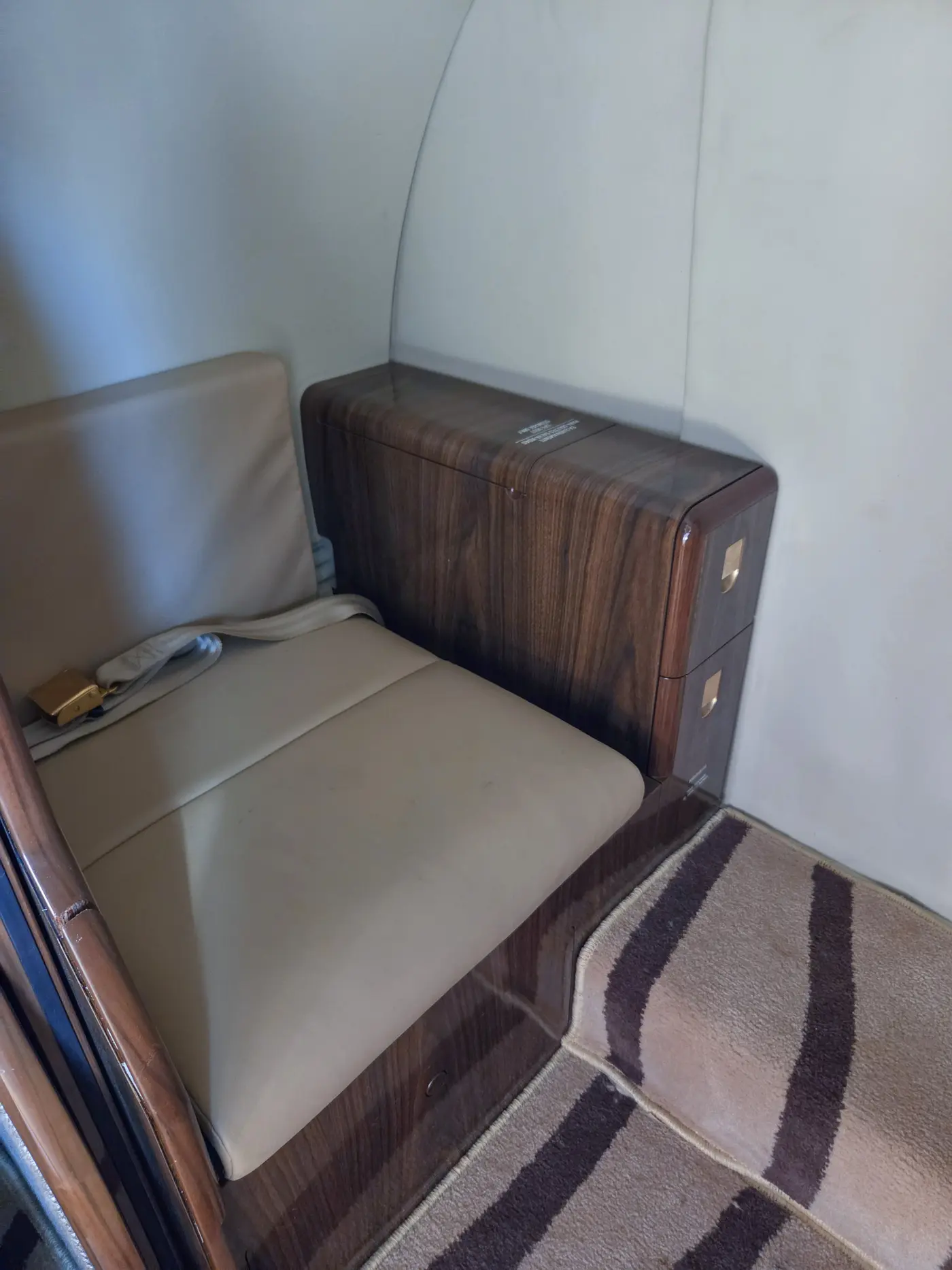 Belted lavatory seat aft
